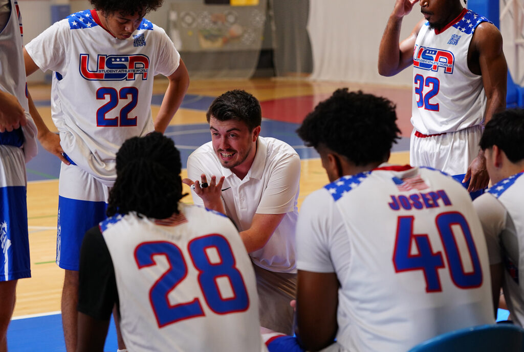 SIC Head Men’s Basketball Coach Sam Swinford talks strategy with the Student Athlete World Tours (SAWUSA) U23 Men’s Basketball Team during the Portugal Basketball Festival in Lisbon. The U.S. team went 5-1 to win gold in the international event.