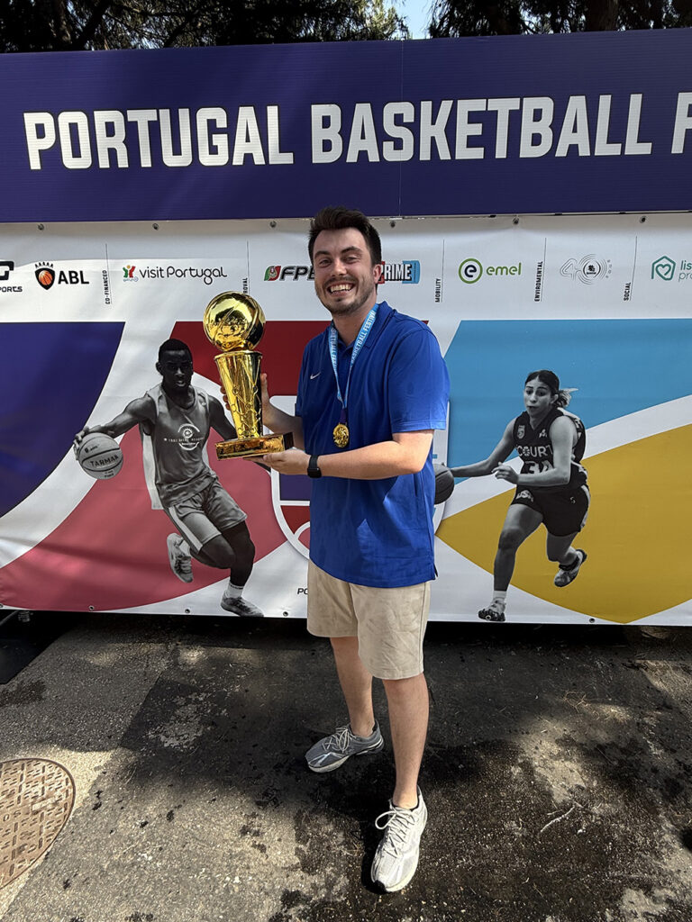 SIC Head Men’s Basketball Coach Sam Swinford celebrates with the championship trophy after leading the Student Athlete World Tours (SAWUSA) U23 Men’s Basketball Team to gold at the Portugal Basketball Festival in Lisbon.